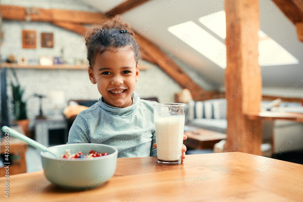 Happy black girl with milk mustache during breakfast at home. Happy black girl with milk mustache during breakfast at home.
