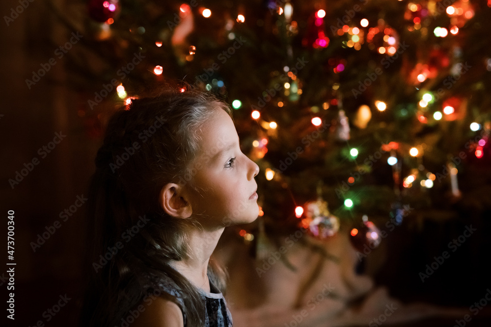 Girl watching TV by a Christmas tree Girl watching TV by a Christmas tree
