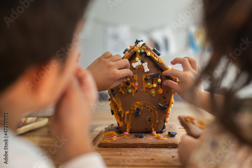 Kids making and eating haunted gingerbread house photo