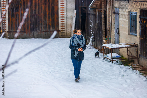 dziewczyna z pieskiem karmi ptaki chodząca po śniegu zima szalik mróz