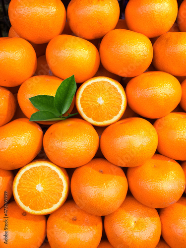 Bild auf Leinwand fresh orange fruits with leaves as background, top view