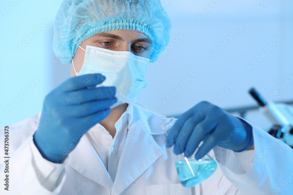 Scientist dripping sample into flask in laboratory. Medical research Scientist dripping sample into flask in laboratory. Medical research