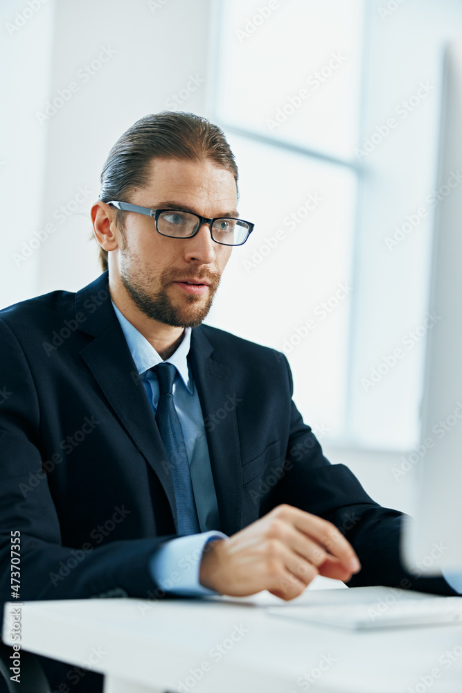 male manager at his desk working in front of a computer male manager at his desk working in front of a computer
