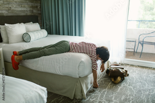 Teen boy relaxing in hotel bedroom