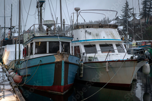 White and green boats on a snowy winter dock in British Columbia © Liam