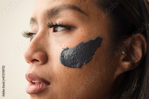 Model wearing grey clay mask on her face photo