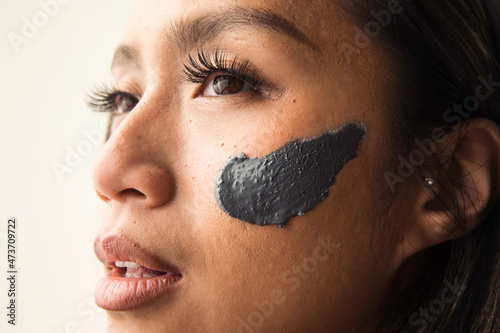 Model wearing grey clay mask on her face