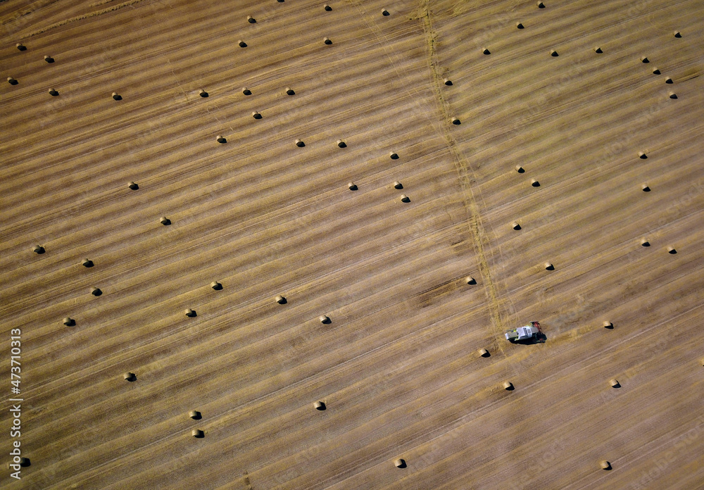 Hay bales harvester in French countryside, aerial shot