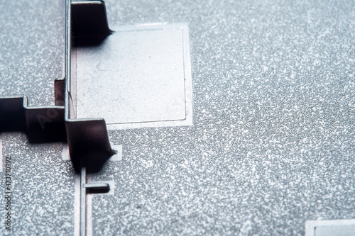 The inner part of the case of a modern device made of metal and plastic. Design for fastening circuits and device elements. Close-up in soft focus at high magnification.