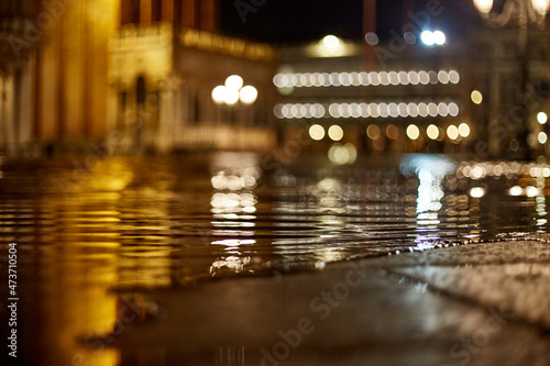 Floodwaters seep, Venice sidewalk pavement, night high tide photo