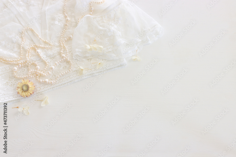 Background of white delicate lace fabric, dry flowers and pearls