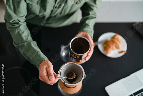 Crop guy brewing coffee at home