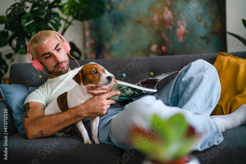 Dog owner reading magazine on sofa photo