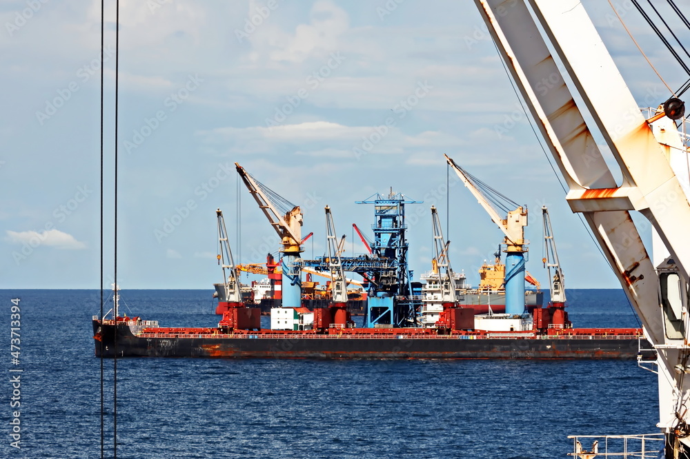 Various bulk carriers, vessels, and tugboats in port under cargo ...