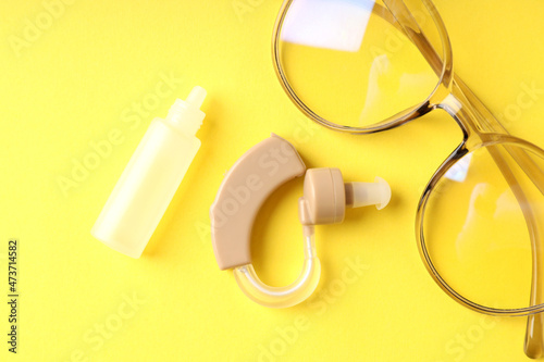 Concept of health care with hearing aid on yellow background