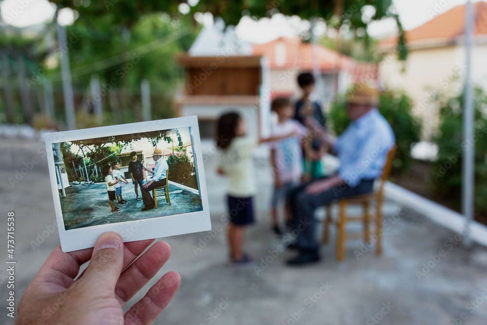 © Nasos Zovoilis/Stocksy - Man's hand holding instant photo