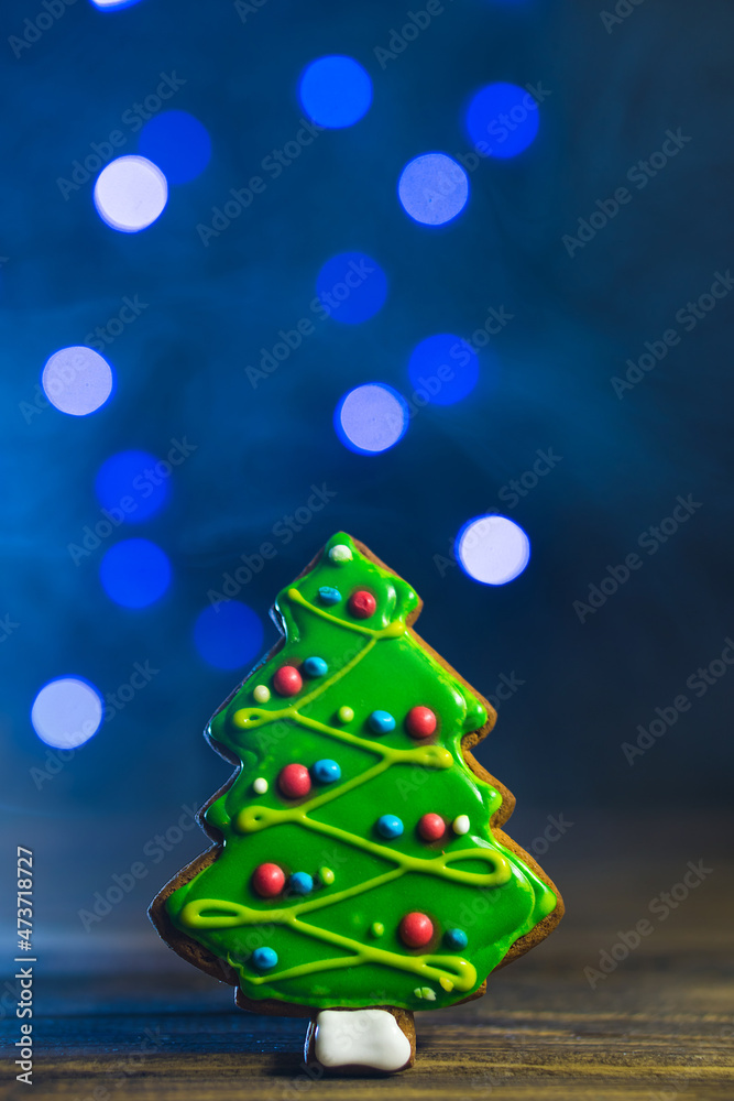 Gingerbread in shape of fir-tree. Cookie on blurred blue background, soft focus, copy space. Gingerbread in shape of fir-tree. Cookie on blurred blue background, soft focus, copy space.