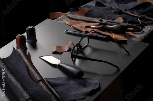 Photos Work table with the tool of a craftsman for the manufacture of leather goods