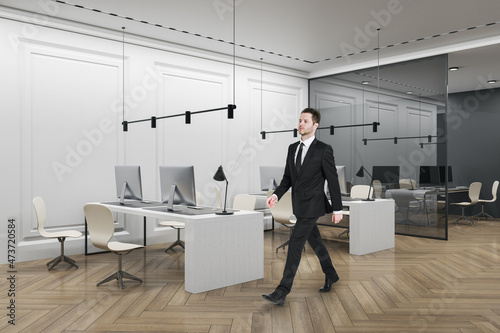 Wallpaper Mural Thoughtful businessman walking in modern coworking office interior with furniture, wooden flooring, concrete walls, equipment and daylight. Workplace, CEO and executive concept. Torontodigital.ca