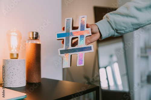 Girl holding holographic hashtag sign at home photo