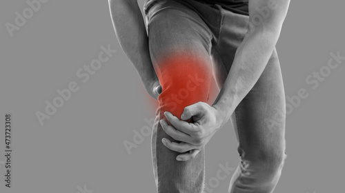 Obraz na plátne Man who hurt his knee is touching red inflamed area