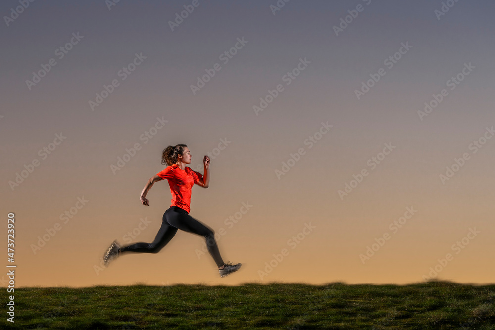 Female sportsperson jogging over land during sunset Female sportsperson jogging over land during sunset