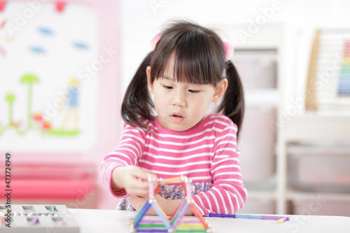 young girl playing creative 3d shape toy for homeschooling
