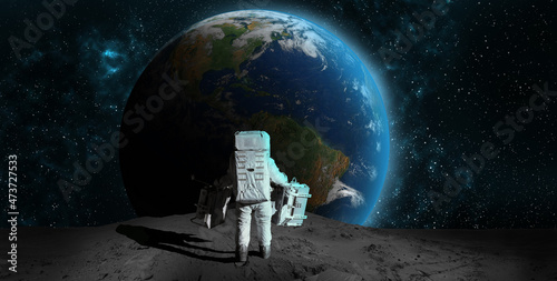 Fototapeta Naklejka Na Ścianę i Meble -  Astronaut on rock surface moon in space. Spacewalk.Astronaut standing looking at the Earth on lunar moon landing mission.Nebula,sun,planet.Elements of this image furnished by NASA.3D illustration