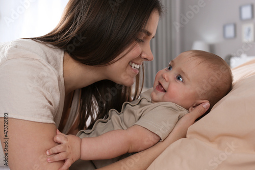 Happy young mother with her cute baby at home, closeup