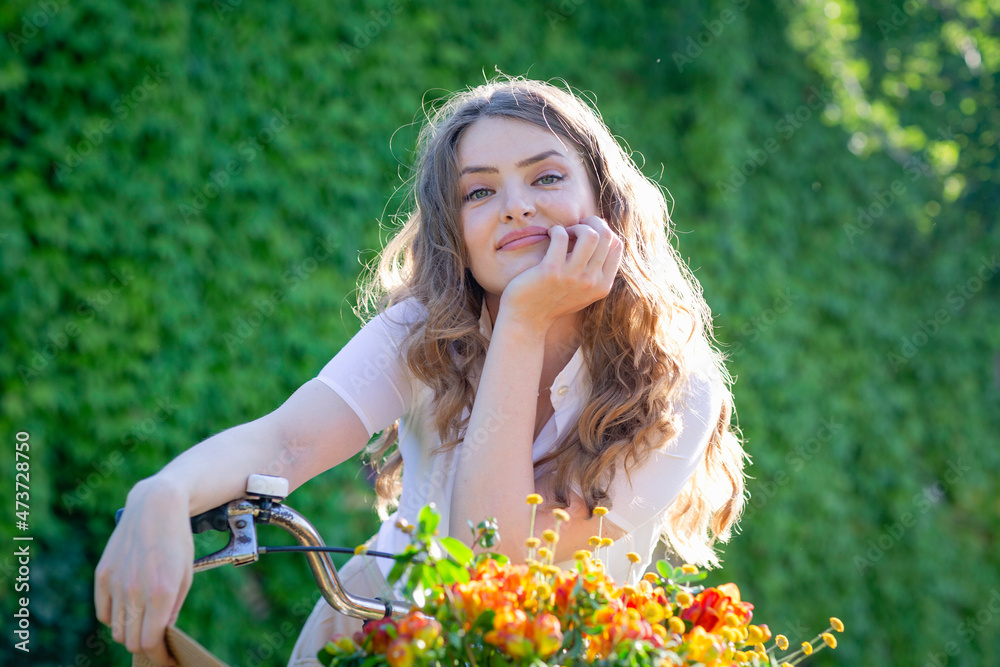 Beautiful woman leaning while sitting on bicycle during sunny day Beautiful woman leaning while sitting on bicycle during sunny day