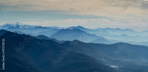 Amazing drone aerial landscape at the Italian Alps in winter and autumn. Morning panorama. Fall sunrise at the alps with moisture and pollution in the air. Silhouette of the mountains and hills