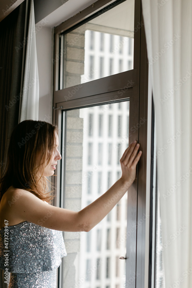Bride Looking out Hotel Window into City Bride Looking out Hotel Window into City