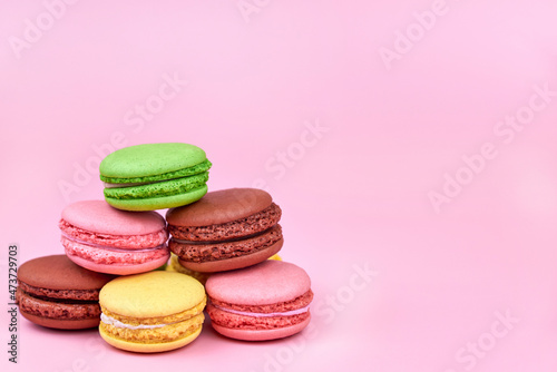 Heap of bright cookies on a pink background, copy space.