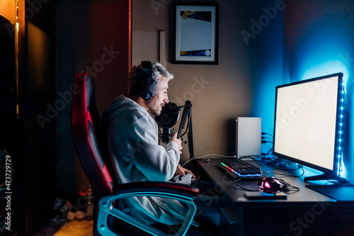Gamer doing online streaming while playing game on computer at home