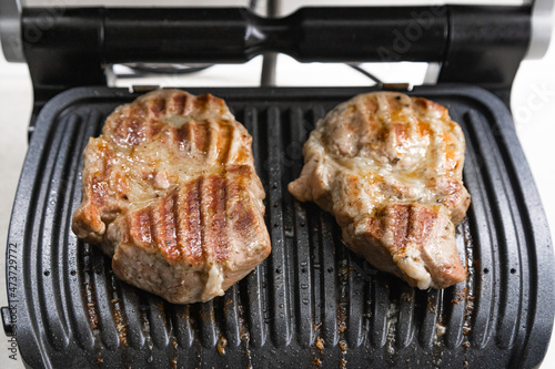 Hot steak on the electric grill at home in the kitchen