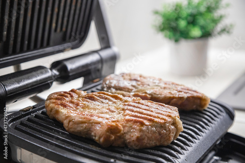 Hot steak on the electric grill at home in the kitchen