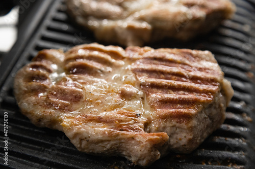 Hot steak on the electric grill at home in the kitchen