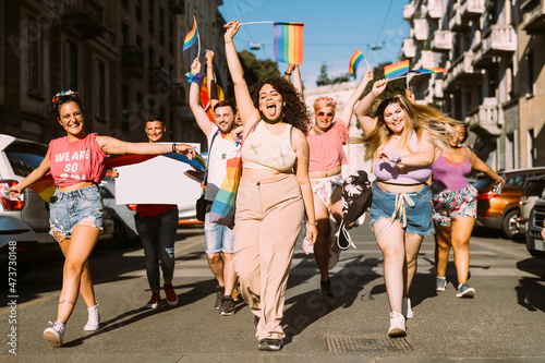 Cheerful female and male activists protesting for equal rights on street during sunny day