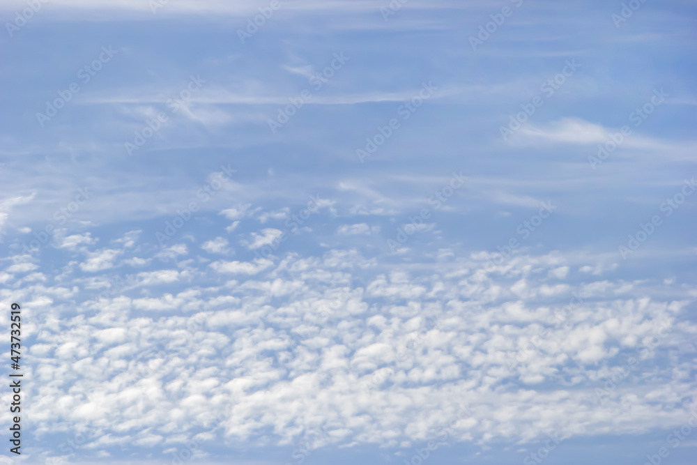 Background of white fluffy clouds on the background of soft blue sky.
