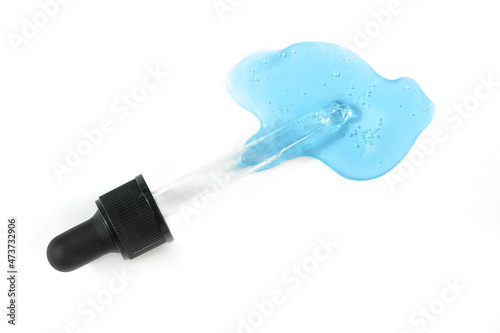 Pipette with blue hyaluronic acid isolated on white background. Cosmetics and healthcare concept closeup. Dose of serum or retinol with air bubbles. Top view. Luxury gel or beauty product presentation © Lavsketch
