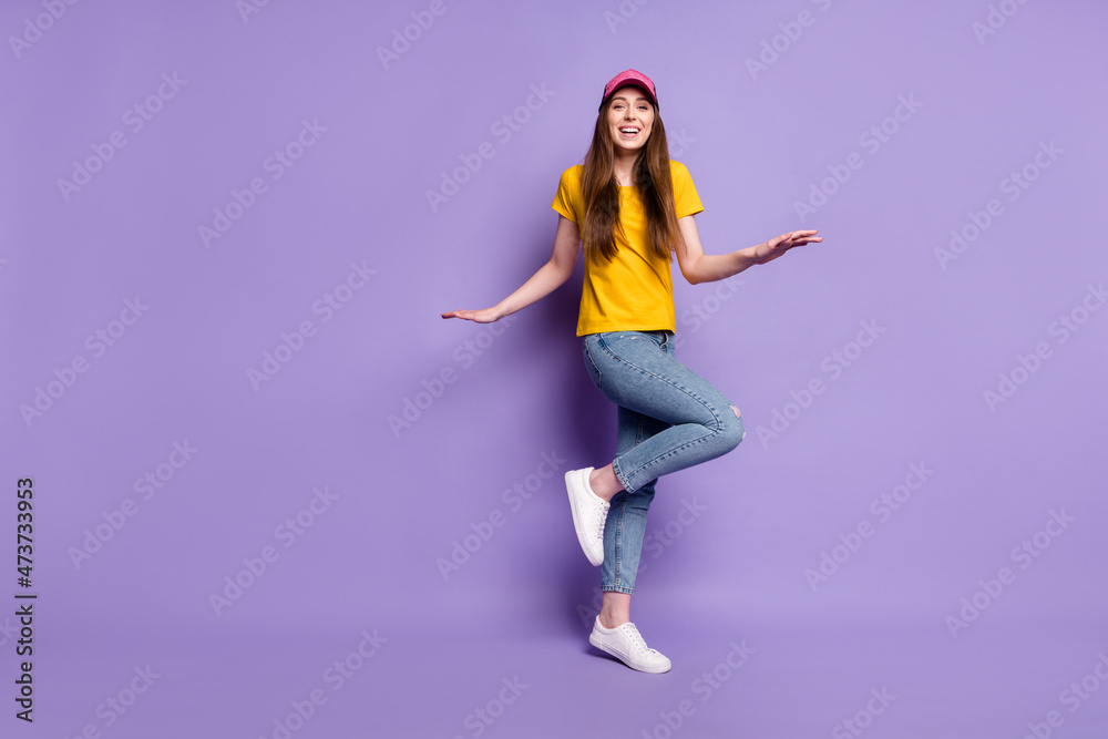 Full length photo of happy cheerful young woman wear jeans headwear street style isolated on violet color background