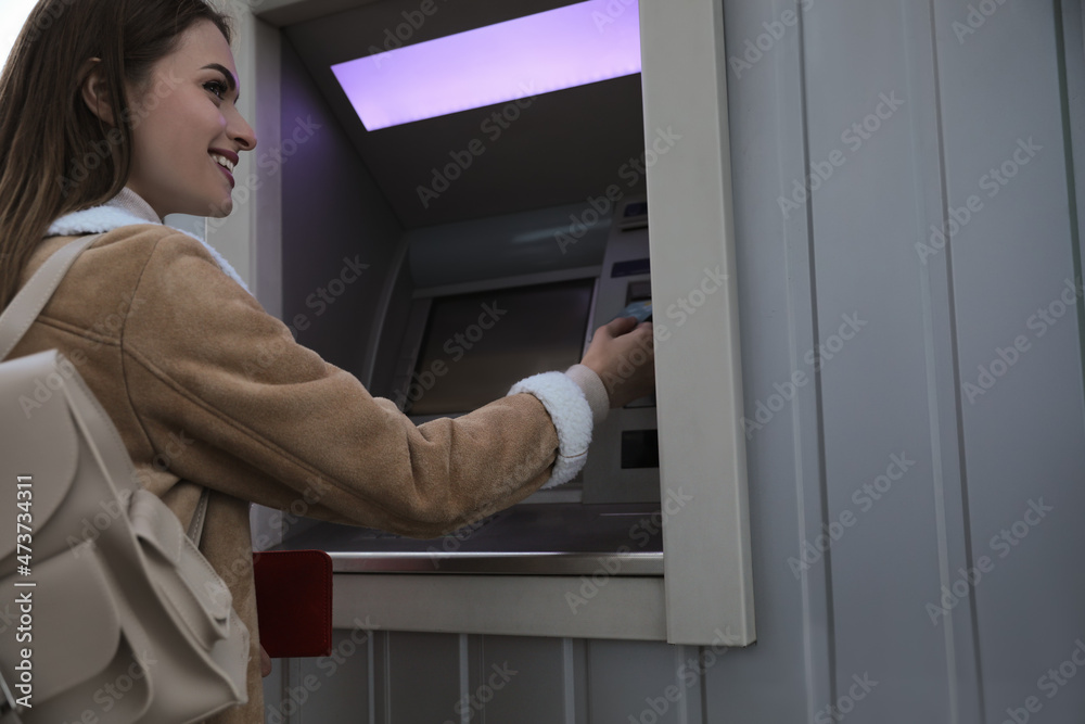 Young woman using cash machine for money withdrawal outdoors Young woman using cash machine for money withdrawal outdoors