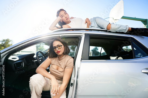 Diverse women sitting on SUV car photo