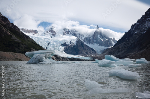 Laguna Torre lake with icebergs breaking away from glacier. Panoramic view of Cerro Torre mountain in clouds and glacier Torre. One day trek to Laguna Torre from El Chalten, Patagonia, Argentina