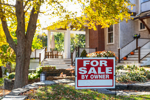 House for Sale sign in front of Residence in Autumn