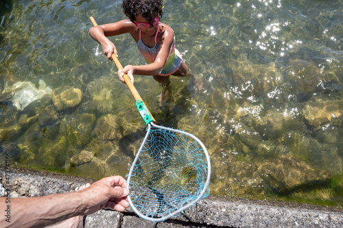 Man and girl hold net with bluegill fish photo