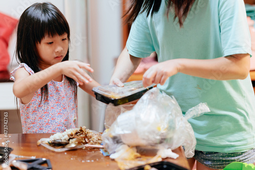 Little girl clean up dining table garbage