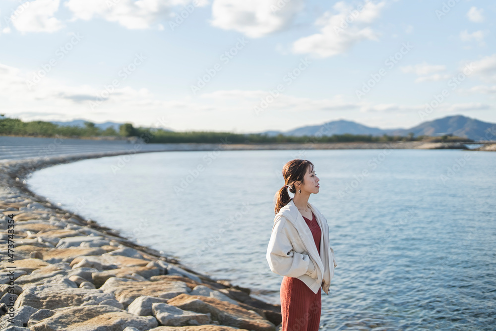 海岸沿いを散策する女性