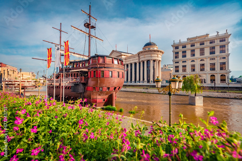 Colorful spring cityscape of capital of North Macedonia - Skopje with old wooden sailboat and blooming flowers. Traveling concept background. photo