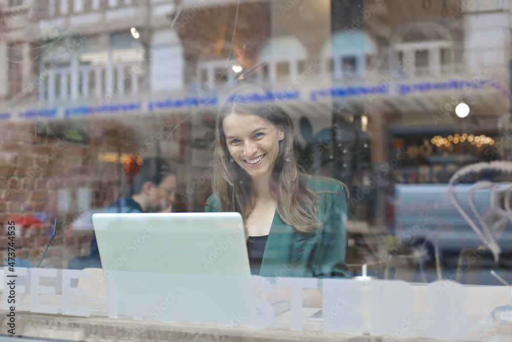 young woman photographed through the glass of a bar window young woman photographed through the glass of a bar window